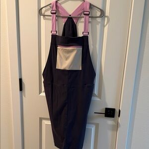 cotopaxi Purple Bib Overalls with Pink Straps and Cream Pocket
NWOT
